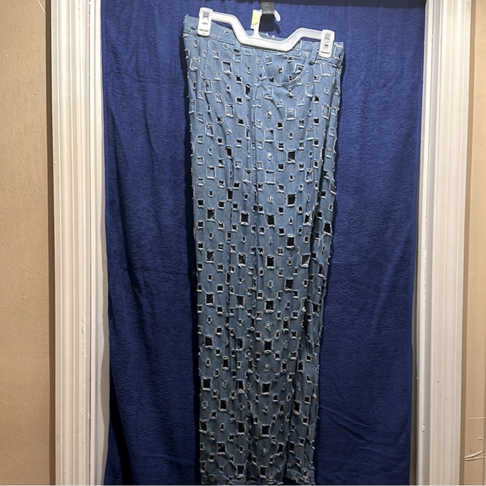Women’s jeans, small squared holes meticulously placed all over.